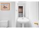 Clean bathroom sink with pedestal and mirrored cabinet, illuminated by stylish light fixture at 9469 W Ute Dr, Littleton, CO 80128