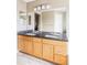 Double vanity in bathroom featuring a large mirror, dual sinks, and modern lighting at 9469 W Ute Dr, Littleton, CO 80128
