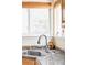 Close-up of kitchen sink featuring granite countertops and a stylish chrome faucet, complemented by natural light from a window at 9469 W Ute Dr, Littleton, CO 80128