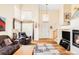 Bright living room featuring high ceilings, large windows, fireplace, and comfortable seating at 9469 W Ute Dr, Littleton, CO 80128