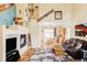 Spacious living room featuring a fireplace, vaulted ceiling, hardwood floors, and dining area at 9469 W Ute Dr, Littleton, CO 80128