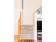 Carpeted stairs with wooden banister leading to the upper level, adjacent to a modern entertainment center at 9469 W Ute Dr, Littleton, CO 80128