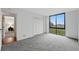 Bedroom with a window view, a closet, gray carpet, neutral walls, and wood floors in the doorway at 1111 Race St # 6B, Denver, CO 80206