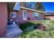 Charming brick home featuring a colorful garden and inviting front entrance with a covered porch and flower-filled planters at 5404 W Rowland Pl, Littleton, CO 80128