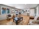 Open living room boasts natural light, hardwood floors, and seamless flow to the kitchen at 5404 W Rowland Pl, Littleton, CO 80128
