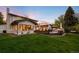 Landscaped backyard with a large lawn and a patio featuring an outdoor kitchen and dining area at 5810 S Galena St, Greenwood Village, CO 80111