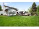 Well-manicured backyard featuring a deck, spacious lawn, and a charming home exterior at 5810 S Galena St, Greenwood Village, CO 80111