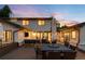Beautiful backyard patio with wood flooring, seating, dining and an outdoor kitchen at sunset at 5810 S Galena St, Greenwood Village, CO 80111