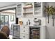 Stylish bar area featuring beverage coolers, sink, and open shelving for glasses and accessories at 5810 S Galena St, Greenwood Village, CO 80111