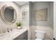 Stylish bathroom features a round mirror, marble countertop, and modern fixtures at 5810 S Galena St, Greenwood Village, CO 80111
