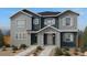 Charming two-story home showcasing gray and blue siding, white trim, and a well-manicured front yard at 2234 Farmlore Dr, Brighton, CO 80601
