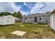 View of house with gray siding in backyard, with a shed, lawn, and concrete pad at 9470 Lillian Ln, Thornton, CO 80229