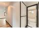 Hallway view of a bathroom with a tiled shower-tub, toilet, and geometric floor at 9470 Lillian Ln, Thornton, CO 80229