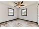 Bedroom boasts wood-look floors, modern fan and two windows at 9470 Lillian Ln, Thornton, CO 80229