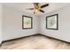 Bright bedroom showcases wood-look floors and natural light from two windows at 9470 Lillian Ln, Thornton, CO 80229