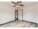 Neutral bedroom with updated vinyl floors, ceiling fan, and white walls at 9470 Lillian Ln, Thornton, CO 80229