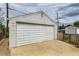 Exterior view of white garage with concrete driveway and some greenery visible at 9470 Lillian Ln, Thornton, CO 80229