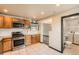 Well-lit kitchen features tile floors, stainless steel appliances, and wood cabinets at 9470 Lillian Ln, Thornton, CO 80229
