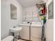 Laundry room features a sink, modern washer and dryer and shelving at 9470 Lillian Ln, Thornton, CO 80229
