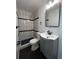 Modern bathroom features a tiled walk-in shower, tiled floors, updated vanity, and modern fixtures at 1550 Eppinger Blvd, Thornton, CO 80229
