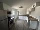 Bright kitchen features stainless appliances, granite counters, white cabinets, and wood flooring at 1550 Eppinger Blvd, Thornton, CO 80229