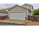 Spacious two-car garage with white door and convenient driveway at 10700 Kimblewyck Cir # 154, Northglenn, CO 80233