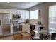 Bright kitchen featuring stainless steel appliances, granite countertops, and subway tile backsplash at 10700 Kimblewyck Cir # 154, Northglenn, CO 80233