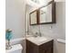 Bathroom featuring dark wood vanity, toilet, and vanity mirror at 6705 S Field St # 822, Littleton, CO 80128