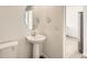 Clean bathroom with pedestal sink, toilet and an oval mirror at 14556 W 91St Ave # C, Arvada, CO 80005