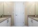 Bright bathroom featuring double sinks, a large mirror, and a separate toilet room at 20234 E Lake Cir, Centennial, CO 80016