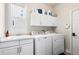 Functional laundry room with white cabinets, sink, and modern washer and dryer at 20234 E Lake Cir, Centennial, CO 80016