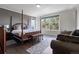 Serene main bedroom with four-poster bed, seating area, and large windows offering picturesque views at 20234 E Lake Cir, Centennial, CO 80016
