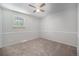 Comfortable bedroom featuring neutral walls, carpet, a ceiling fan, a window for natural light and wainscoting at 8346 W Woodard Dr, Lakewood, CO 80227