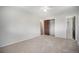 Spacious bedroom with neutral walls, carpet, a ceiling fan, and a closet with a door open to an adjoining bathroom at 8346 W Woodard Dr, Lakewood, CO 80227