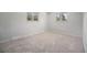 Empty bedroom showcasing carpeted floors and natural light from two large windows at 8346 W Woodard Dr, Lakewood, CO 80227