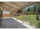 View of the covered patio area and grassy backyard featuring a wood fence at 8346 W Woodard Dr, Lakewood, CO 80227