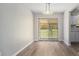 Bright dining area featuring neutral walls, wood floors, and a sliding glass door leading to the backyard at 8346 W Woodard Dr, Lakewood, CO 80227