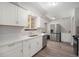 Bright kitchen features white cabinets, stainless steel appliances, light countertops and wood look flooring at 8346 W Woodard Dr, Lakewood, CO 80227
