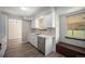 Updated kitchen with a window over the sink, white cabinets, and wood look flooring at 8346 W Woodard Dr, Lakewood, CO 80227