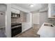 Kitchen showcasing stainless appliances, backsplash, light countertops, white cabinets and wood look flooring at 8346 W Woodard Dr, Lakewood, CO 80227
