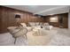 Stylish living room with wood paneling, comfortable seating, modern lighting, and a patterned rug at 8346 W Woodard Dr, Lakewood, CO 80227