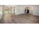 Open-concept room showcasing modern wood flooring, a staircase, and a sliding glass door leading to the backyard at 8346 W Woodard Dr, Lakewood, CO 80227