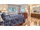 Cozy bedroom with an adjacent bathroom, wood floors, and large window at 3002 E Long S Cir, Centennial, CO 80122