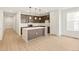 Modern kitchen with stainless steel appliances, island with pendant lighting, and light wood floors at 20665 E 57Th Dr, Aurora, CO 80019