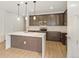 Modern kitchen features an island with quartz countertop, wood cabinets and stainless steel appliances at 20665 E 57Th Dr, Aurora, CO 80019