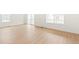 Bright living room with wood floors, large windows, and sliding glass doors at 20665 E 57Th Dr, Aurora, CO 80019