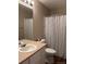 A bathroom with a sink, a mirror and a shower with a patterned shower curtain at 3903 S Quemoy Ct, Aurora, CO 80018