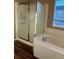 Bathroom including a shower, tub, and window for natural light at 3903 S Quemoy Ct, Aurora, CO 80018