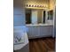 Bathroom including a shower, tub, white vanity, and window for natural light at 3903 S Quemoy Ct, Aurora, CO 80018