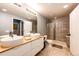 Bathroom with double sinks, tiled floor, shower and tub combination with clear shower curtain at 11699 Pink Phlox Dr, Parker, CO 80134